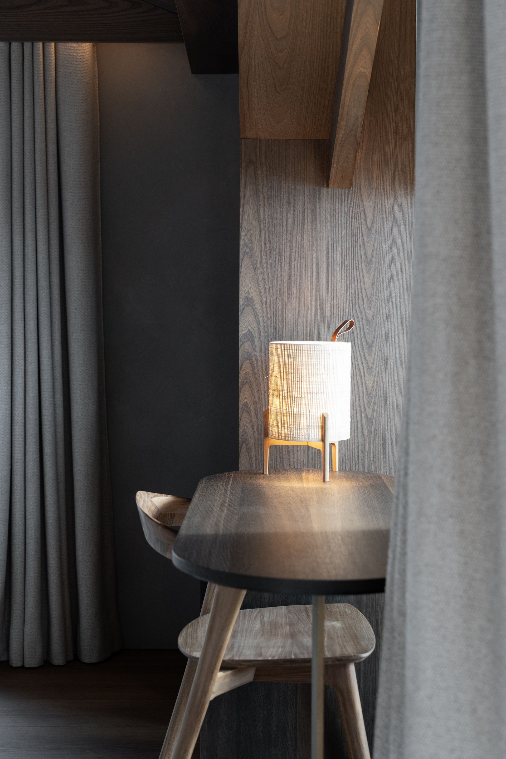 Chalet Escapade A wooden table and chair in a room with a lamp on it.