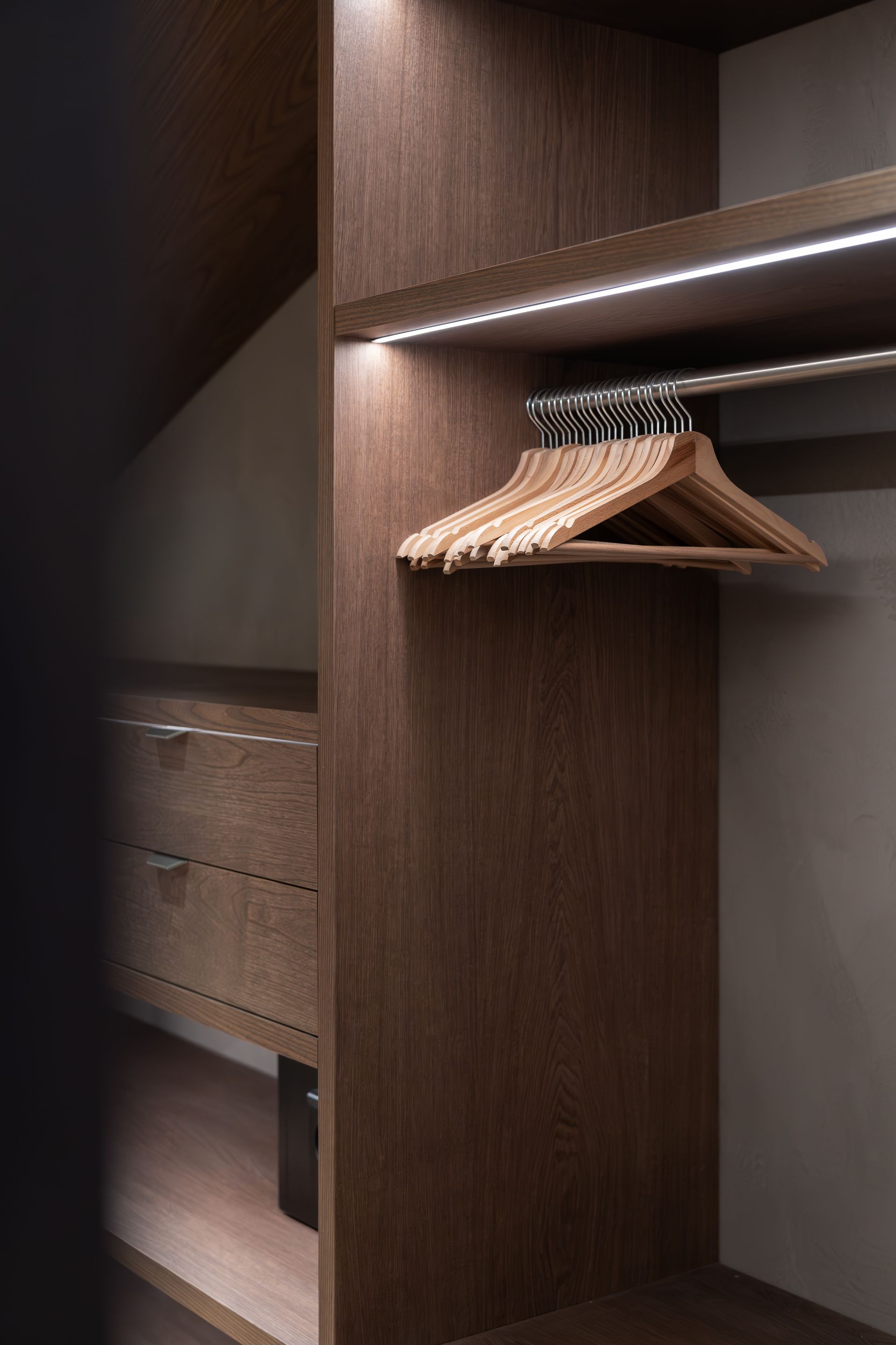 Chalet Escapade A wooden closet with clothes hanging on a rack.