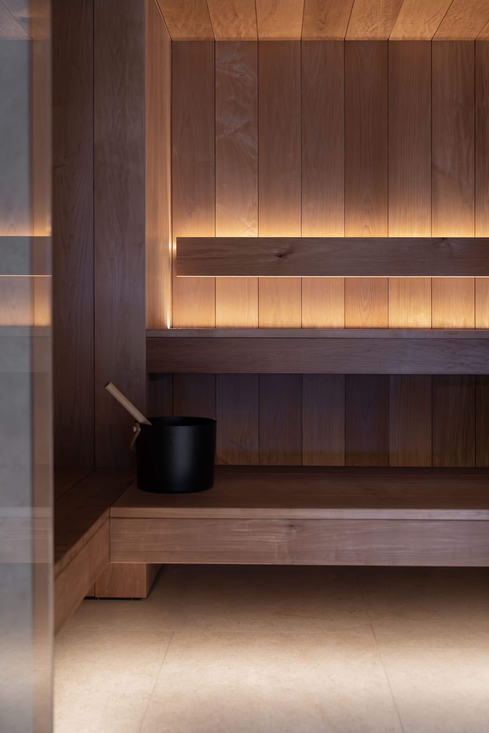 Chalet Escapade A wooden sauna with a black pot on the bench.