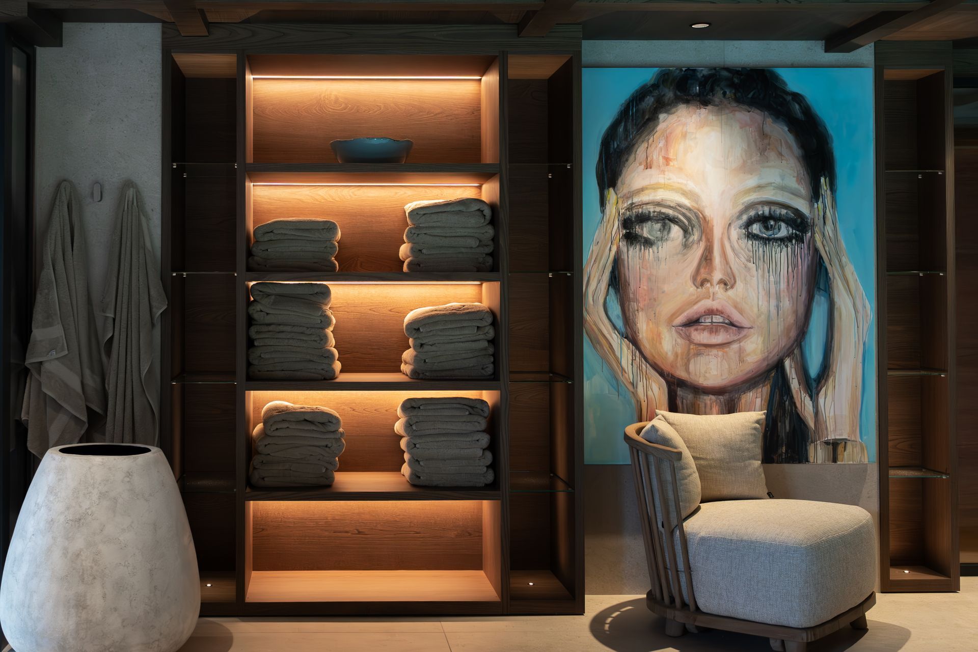 Chalet Escapade A room with a painting of a woman 's face on the wall and a chair.