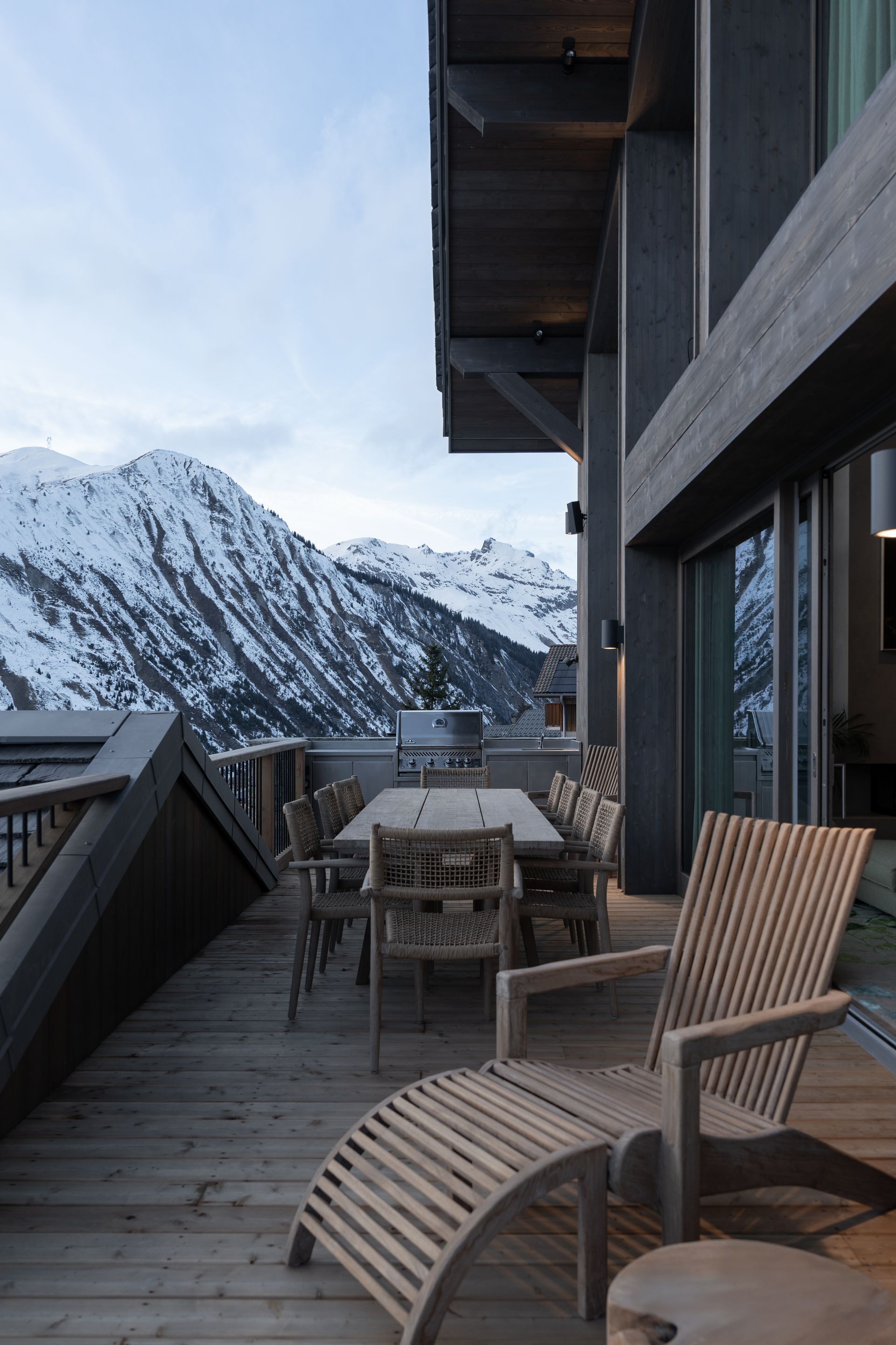 Chalet Escapade A balcony with a table and chairs and a view of the mountains.
