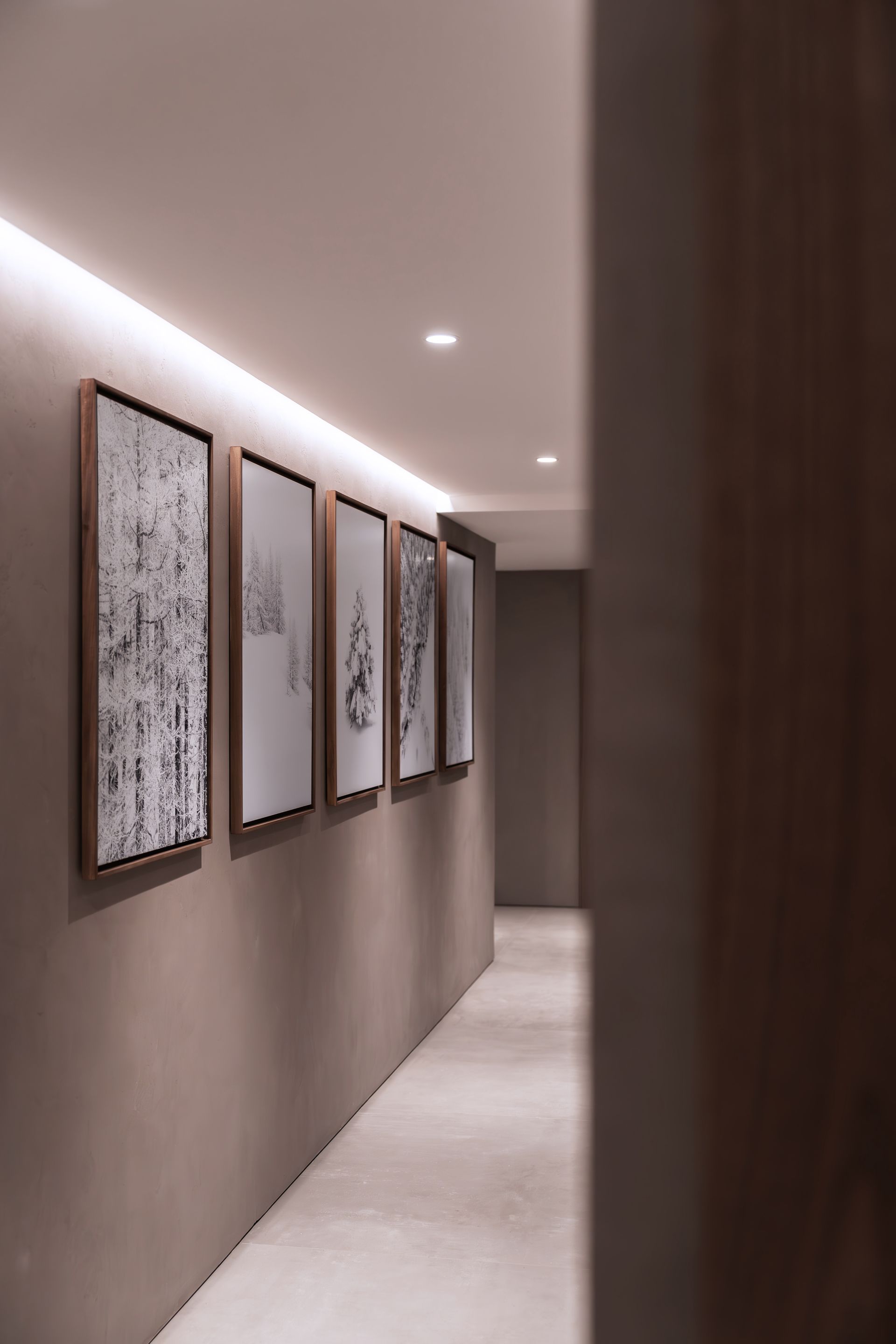 Chalet Escapade A long hallway with a row of paintings on the wall.