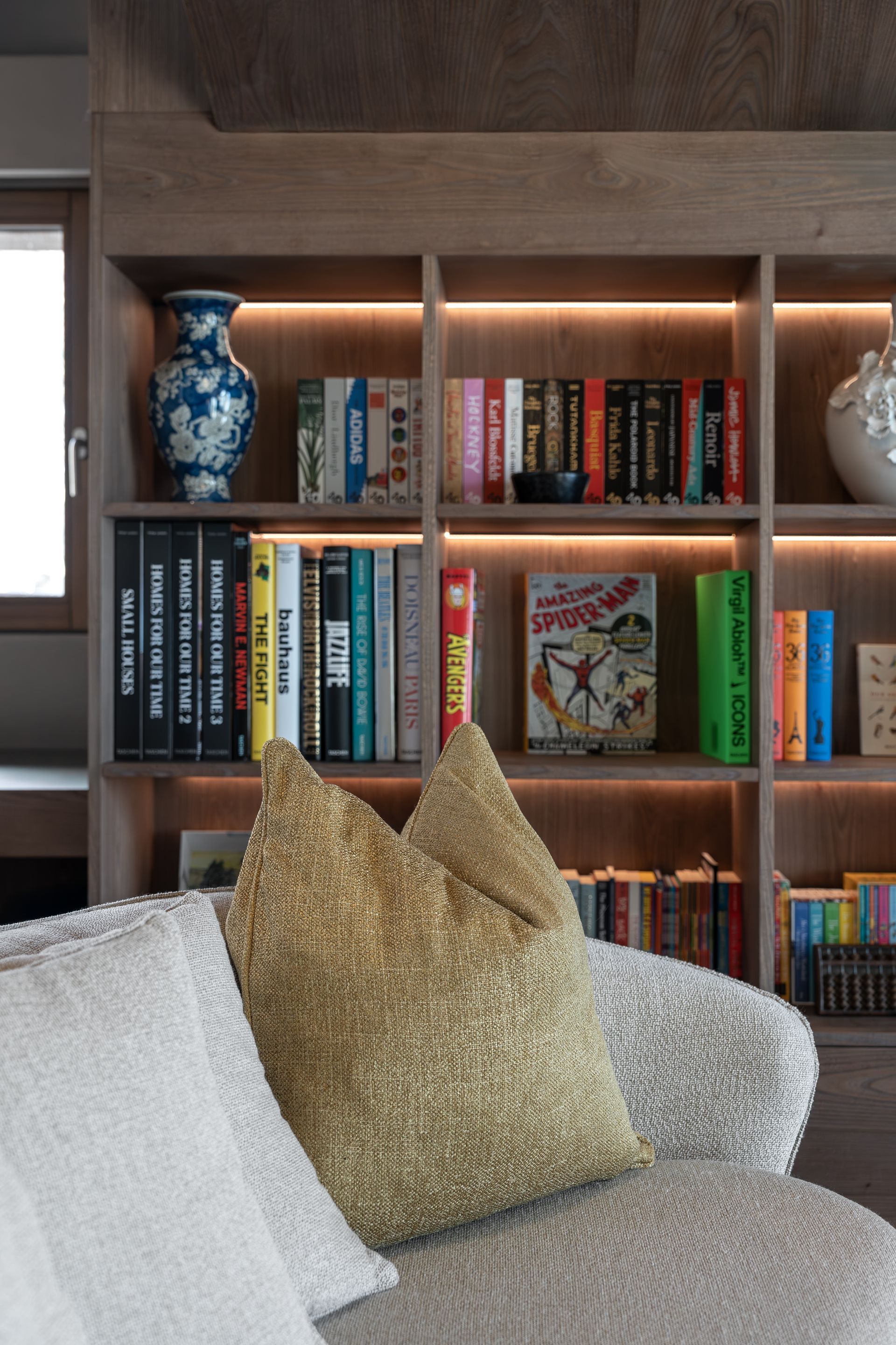 Chalet Escapade A living room with a couch and a bookshelf filled with books.