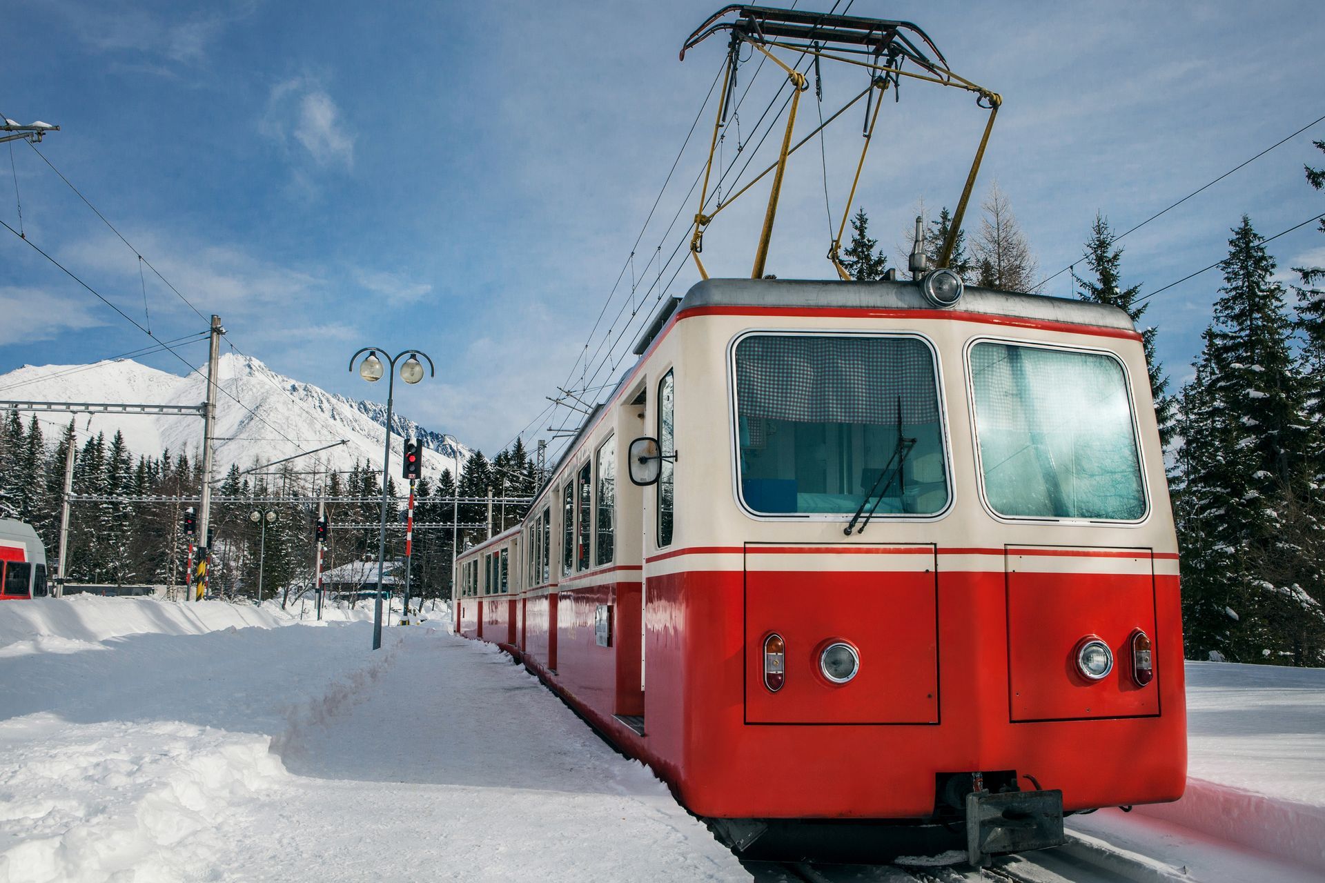 Chalet Escapade A red and white train is sitting on the tracks in the snow.