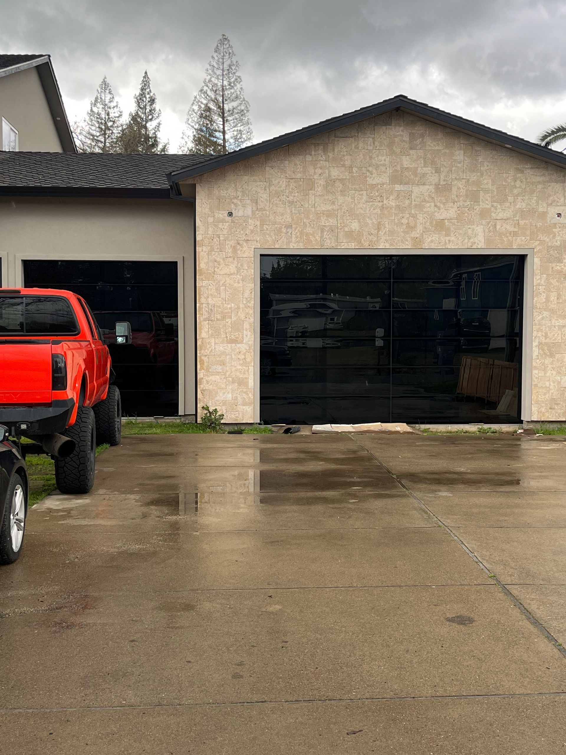 A red truck is parked in front of a garage door repalcement
