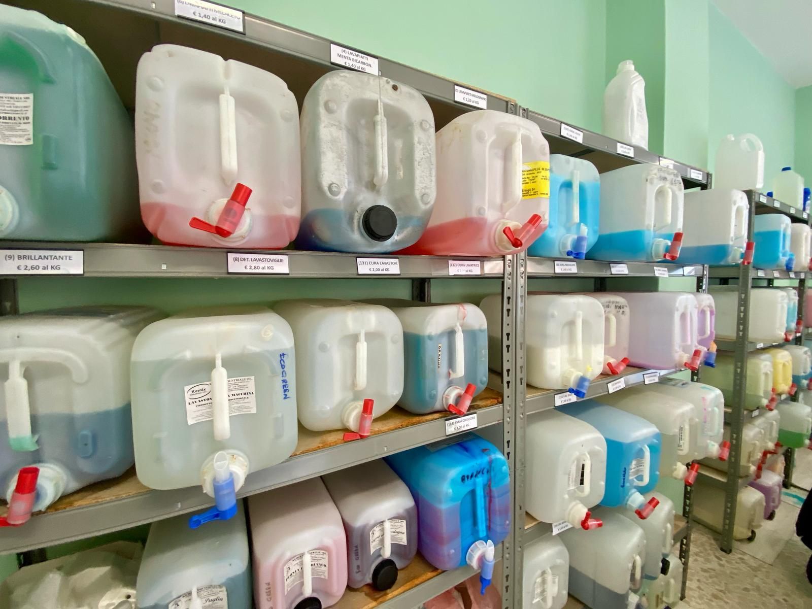 Una fila di scaffali pieni di contenitori di plastica di diversi colori.