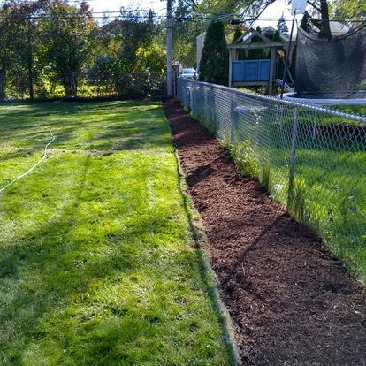 A fenced in yard with a path going through it.