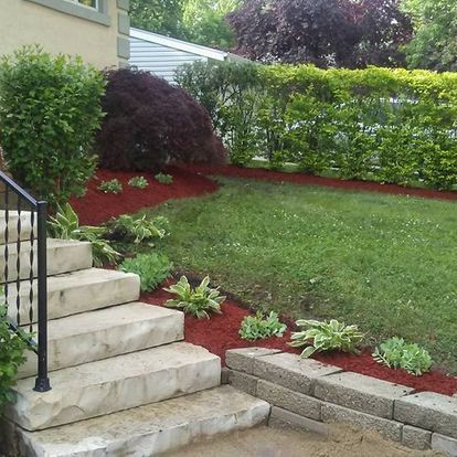 A set of stairs leading up to a lush green yard
