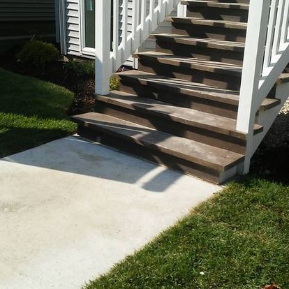 A set of wooden stairs with a white railing