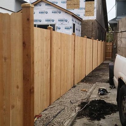 A wooden fence is being built in front of a house