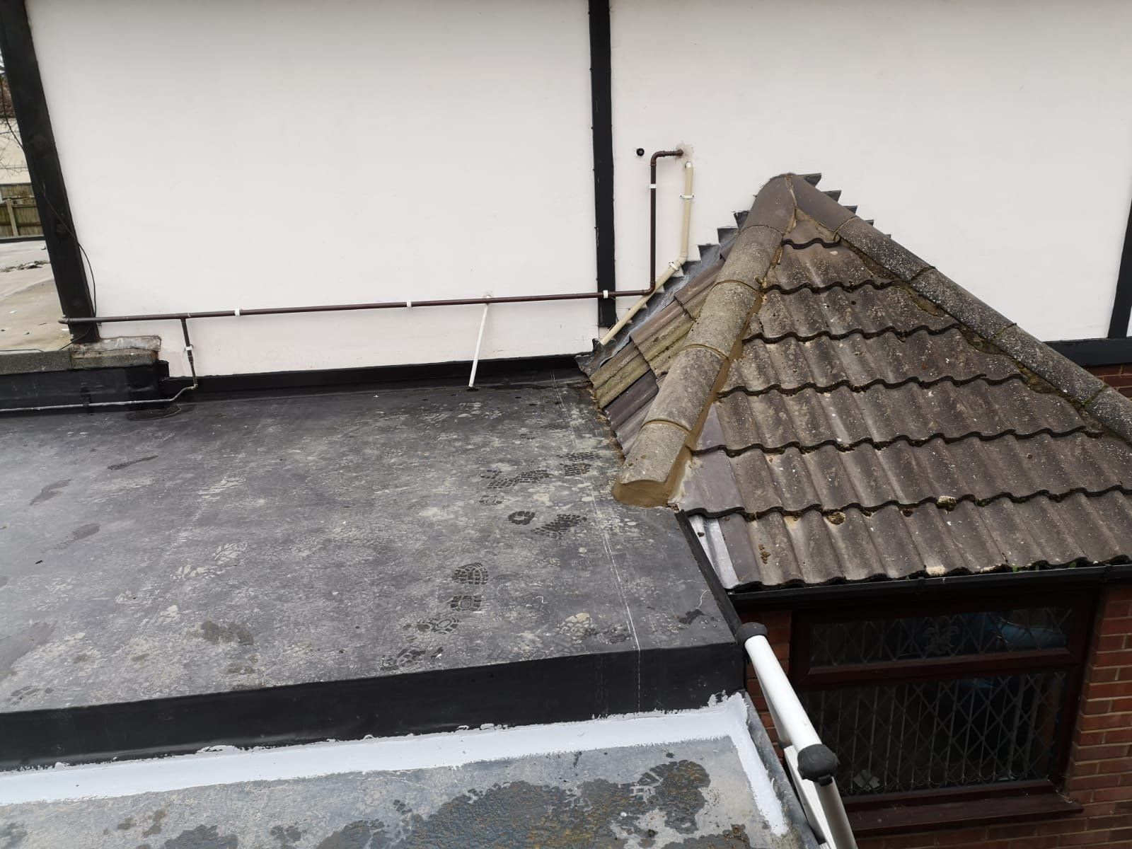 a roof with a gutter and a pipe on it