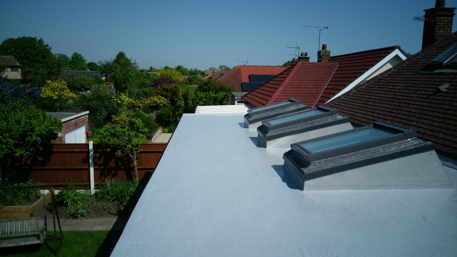 a white roof with a row of skylights on it
