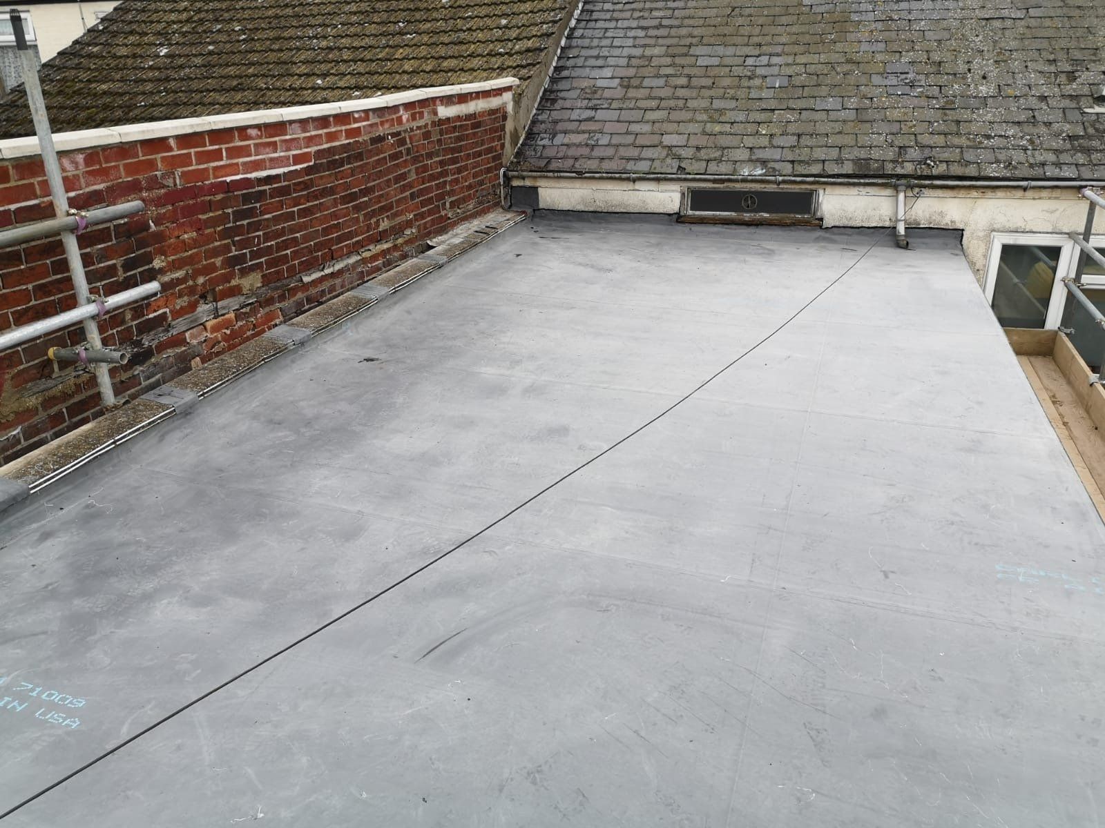 a roof with a brick wall and a gray roof