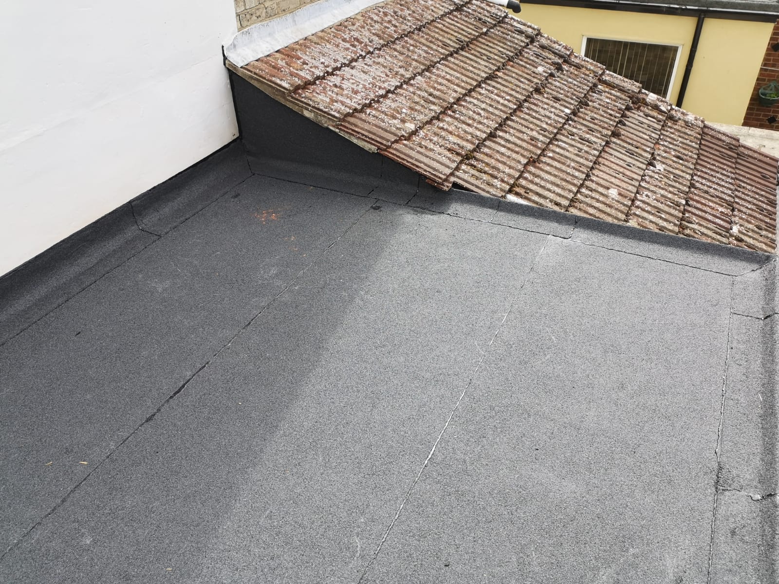 a roof with part tile roof and part black roof