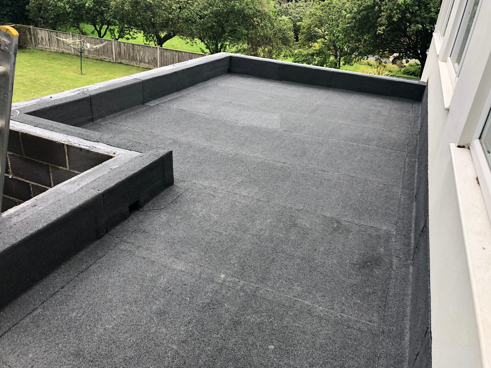 a black roof with a fence in the background