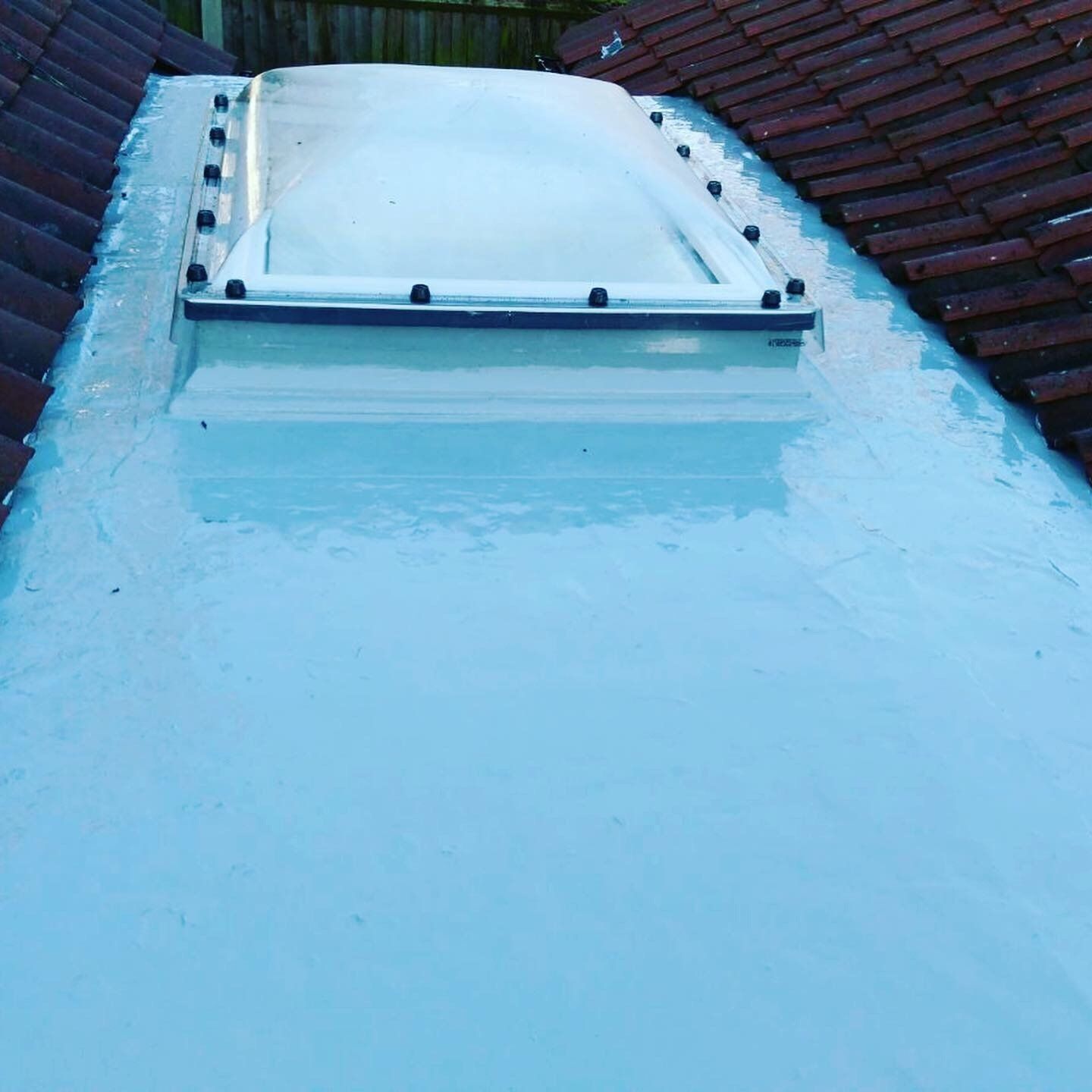 a skylight on the roof of a house with a white roof