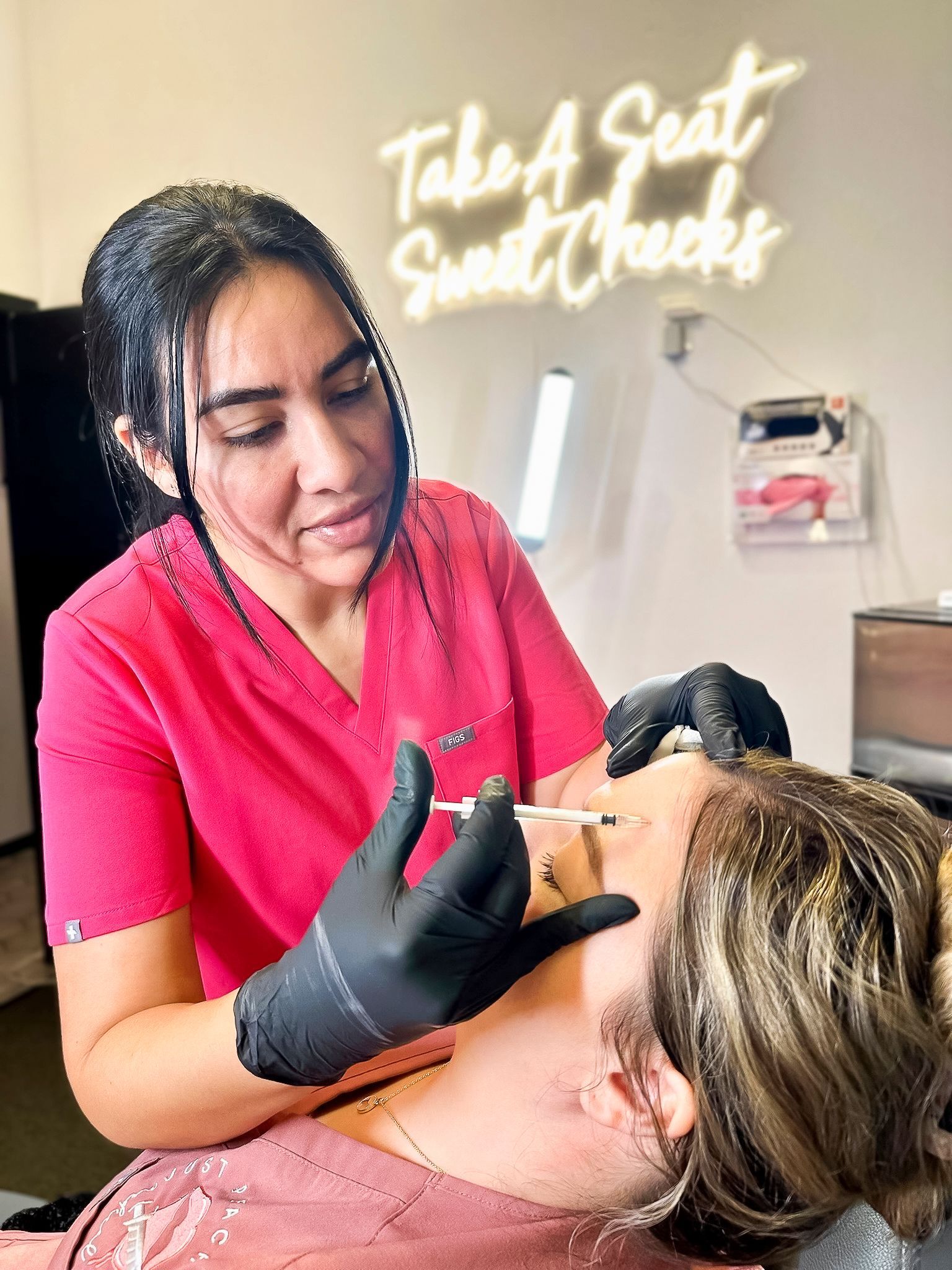 A woman is getting a botox injection in her face.