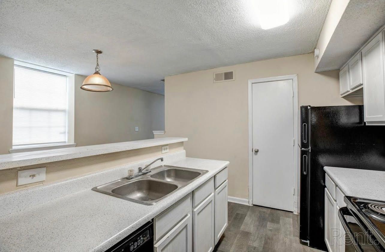 A kitchen with a sink , stove , refrigerator and dishwasher.