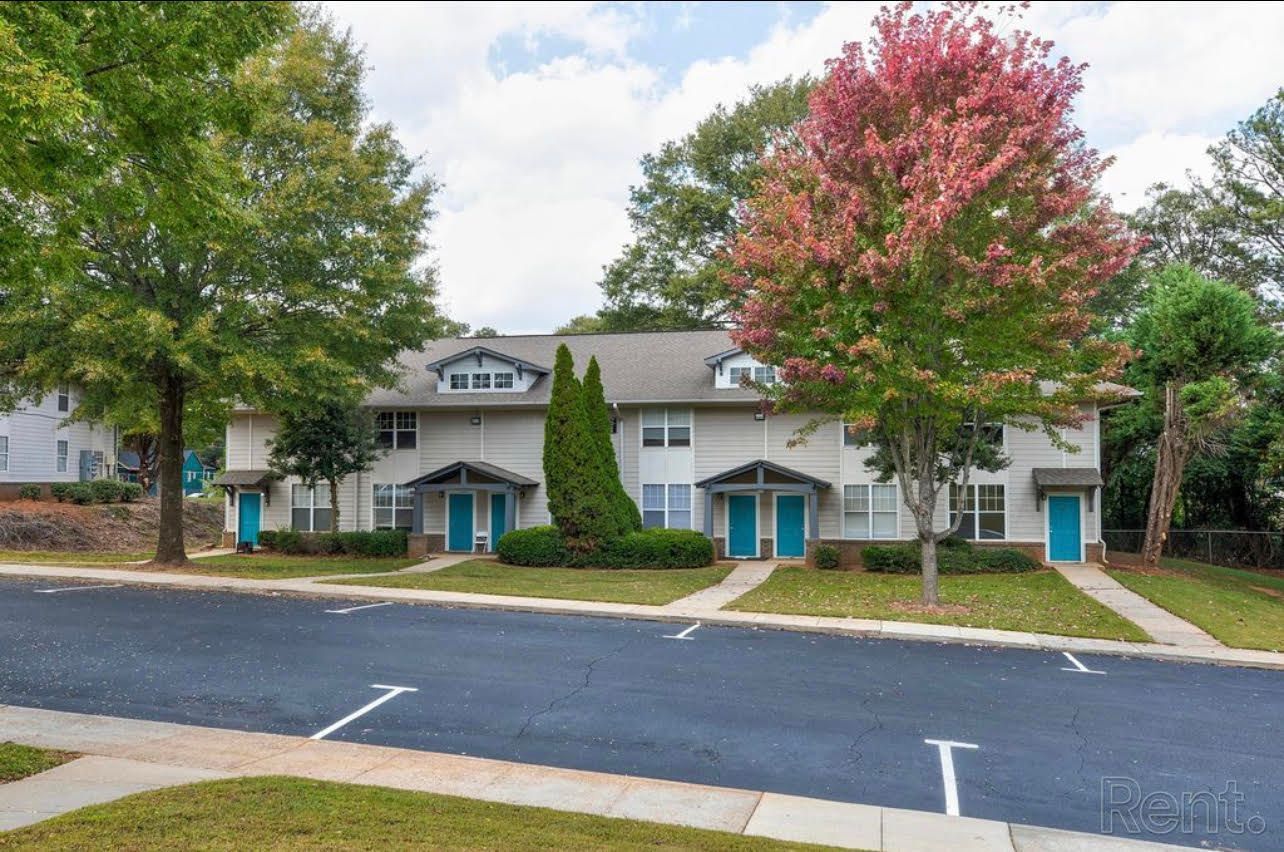 A row of houses with blue doors are sitting next to each other in a residential area.