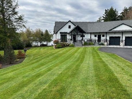 a large house with a lush green lawn in front of it .