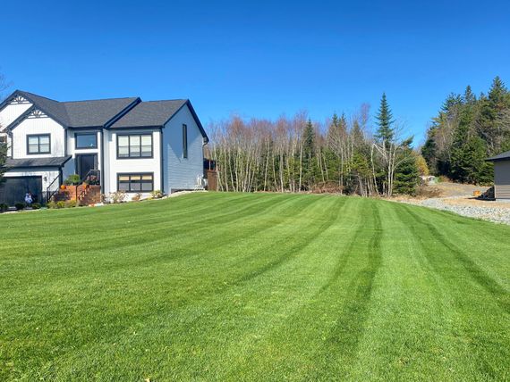 a large house with a lush green lawn in front of it .