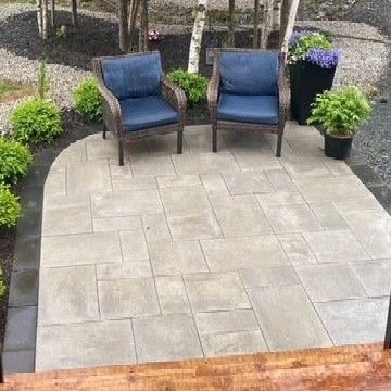 two chairs are sitting on a patio next to a tree .