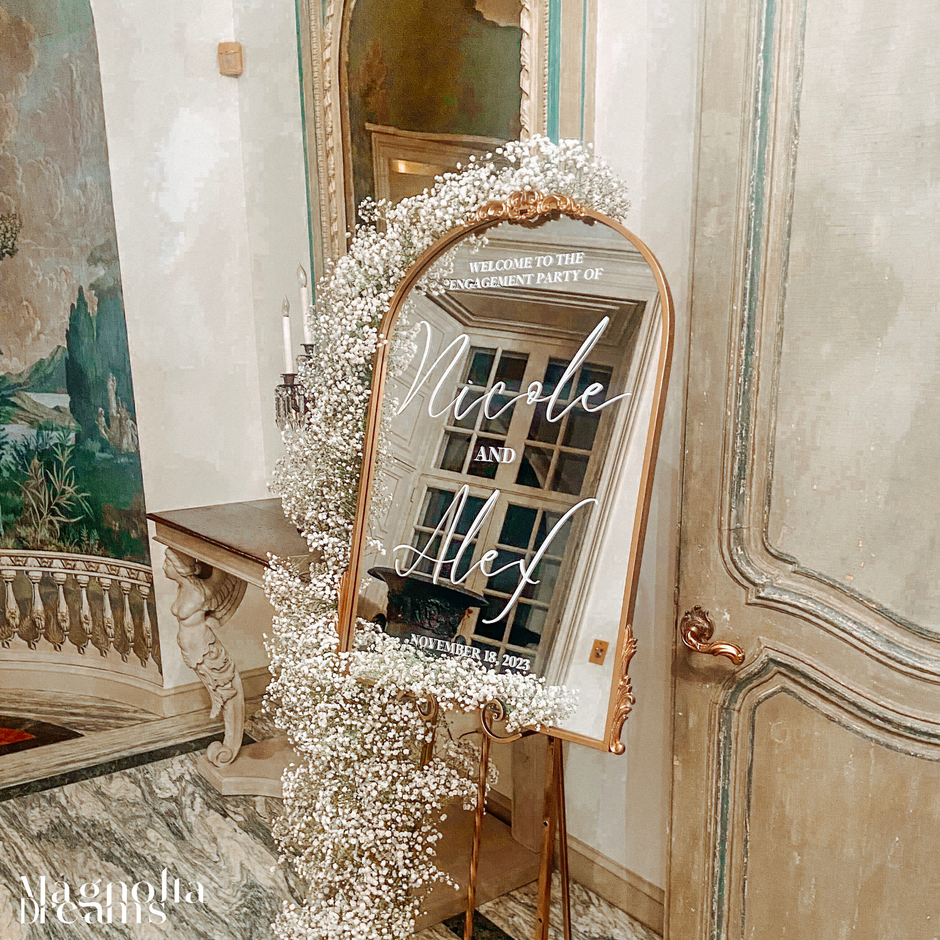 A large mirror with baby 's breath on it at a wedding engagement party