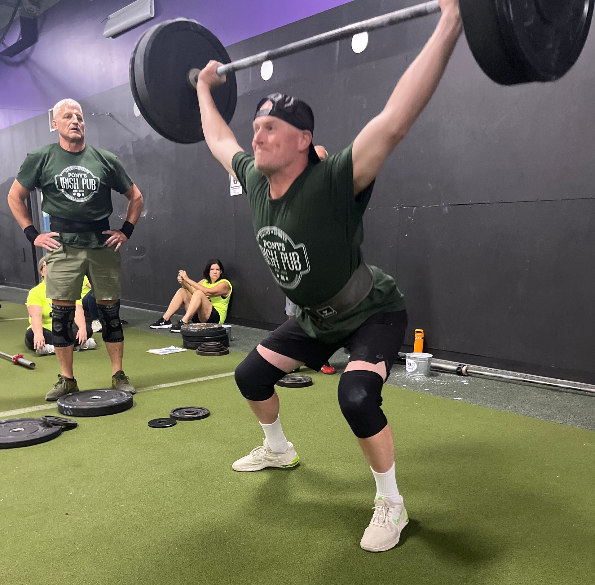 Adults working out together in a CrossFit class, showing support, motivation, and community vibes