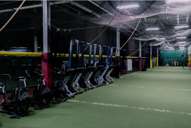 A row of exercise bikes are lined up in a gym.