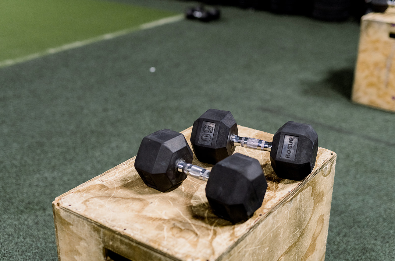 A pair of dumbbells sitting on top of a wooden box.