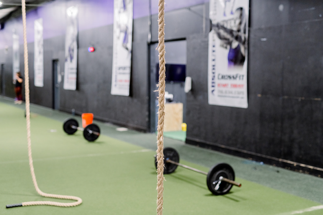 A gym with ropes and barbells on the floor