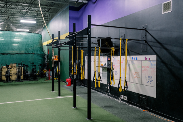 A gym with a lot of exercise equipment and a white board on the wall.