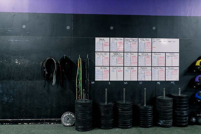 A stack of weights is sitting in front of a wall with a calendar on it.