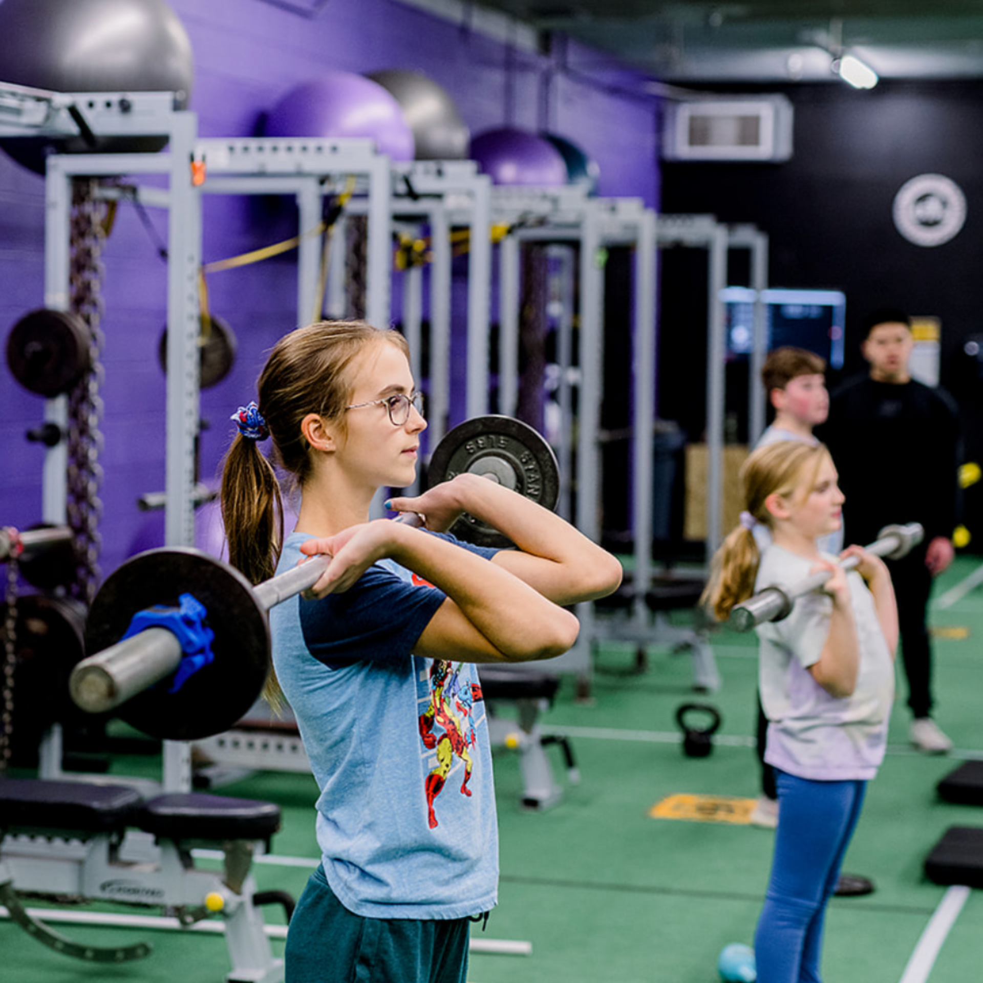 Kids learning strength training with coach, building confidence in a safe fitness environment