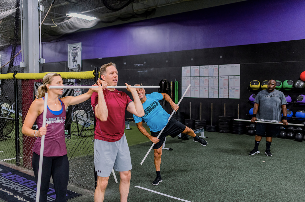 CrossFit class with beginners learning exercises with a coach in a supportive environment