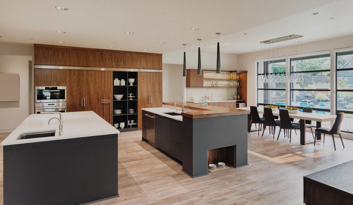 A kitchen with a large island in the middle and a dining room.