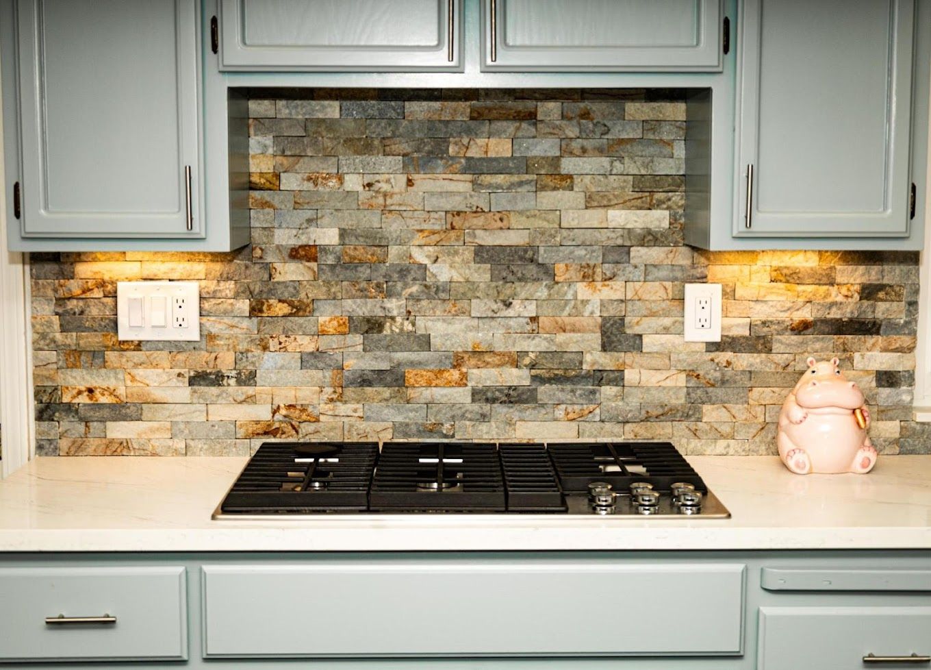 A kitchen with a stove top oven and a brick wall behind it.