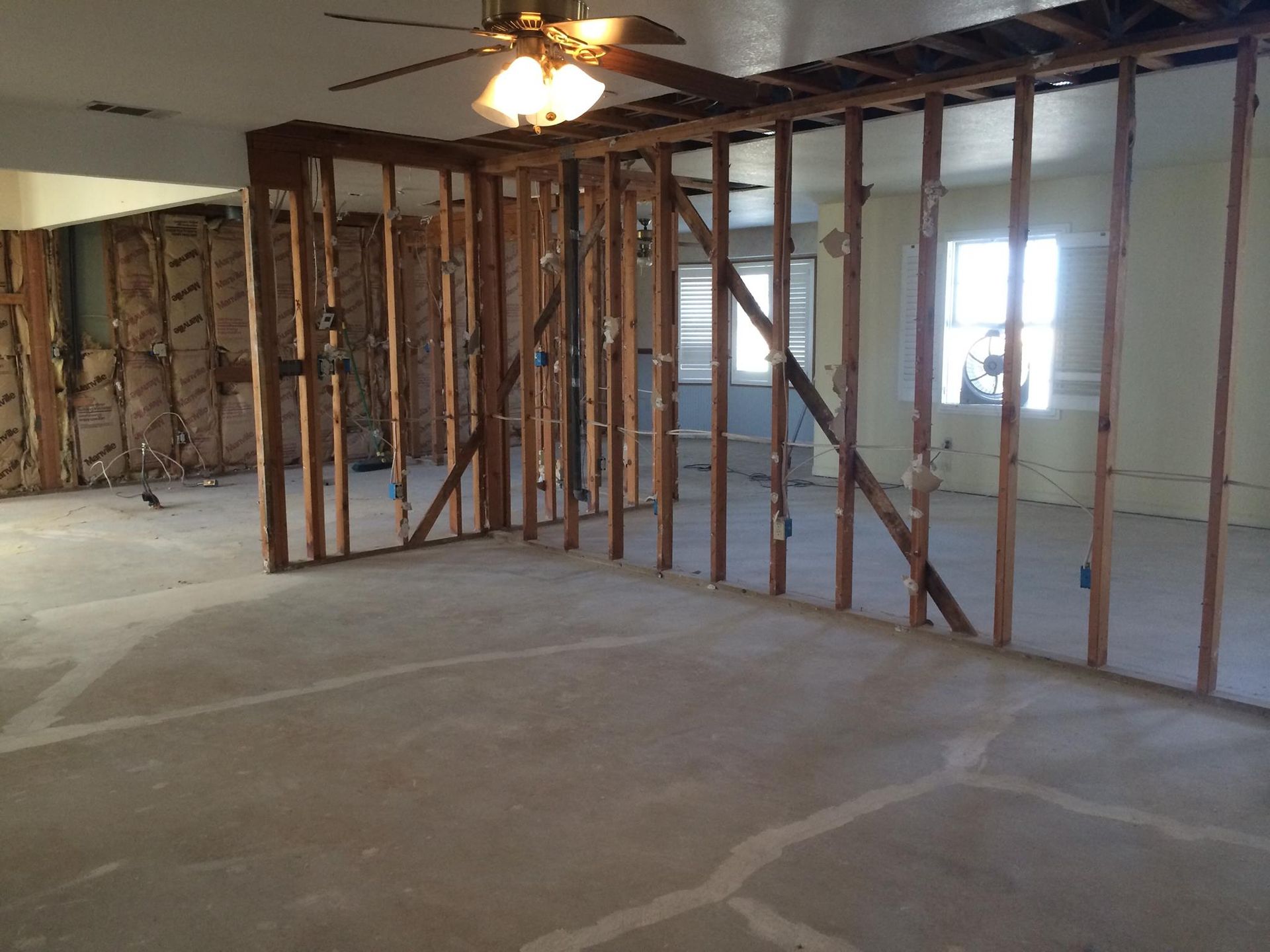 An empty room with a ceiling fan in the corner