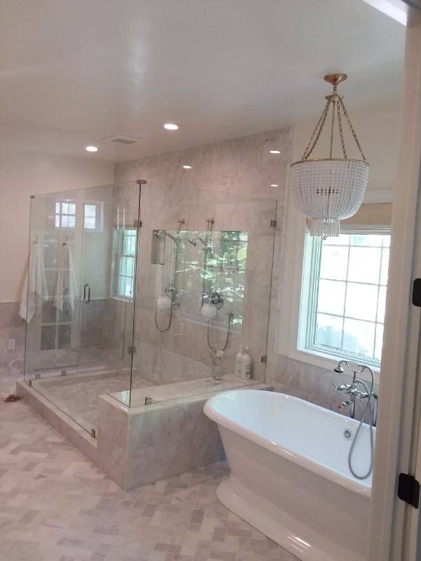 A bathroom with a tub , shower , and window.