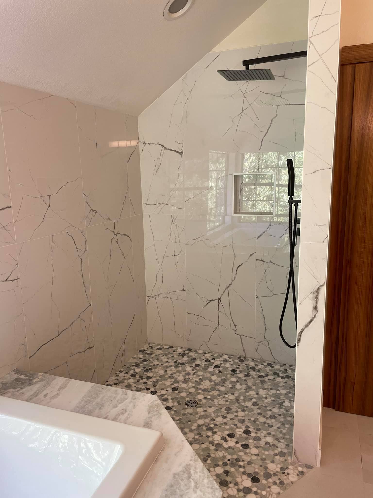 A bathroom with a walk in shower and a bathtub.