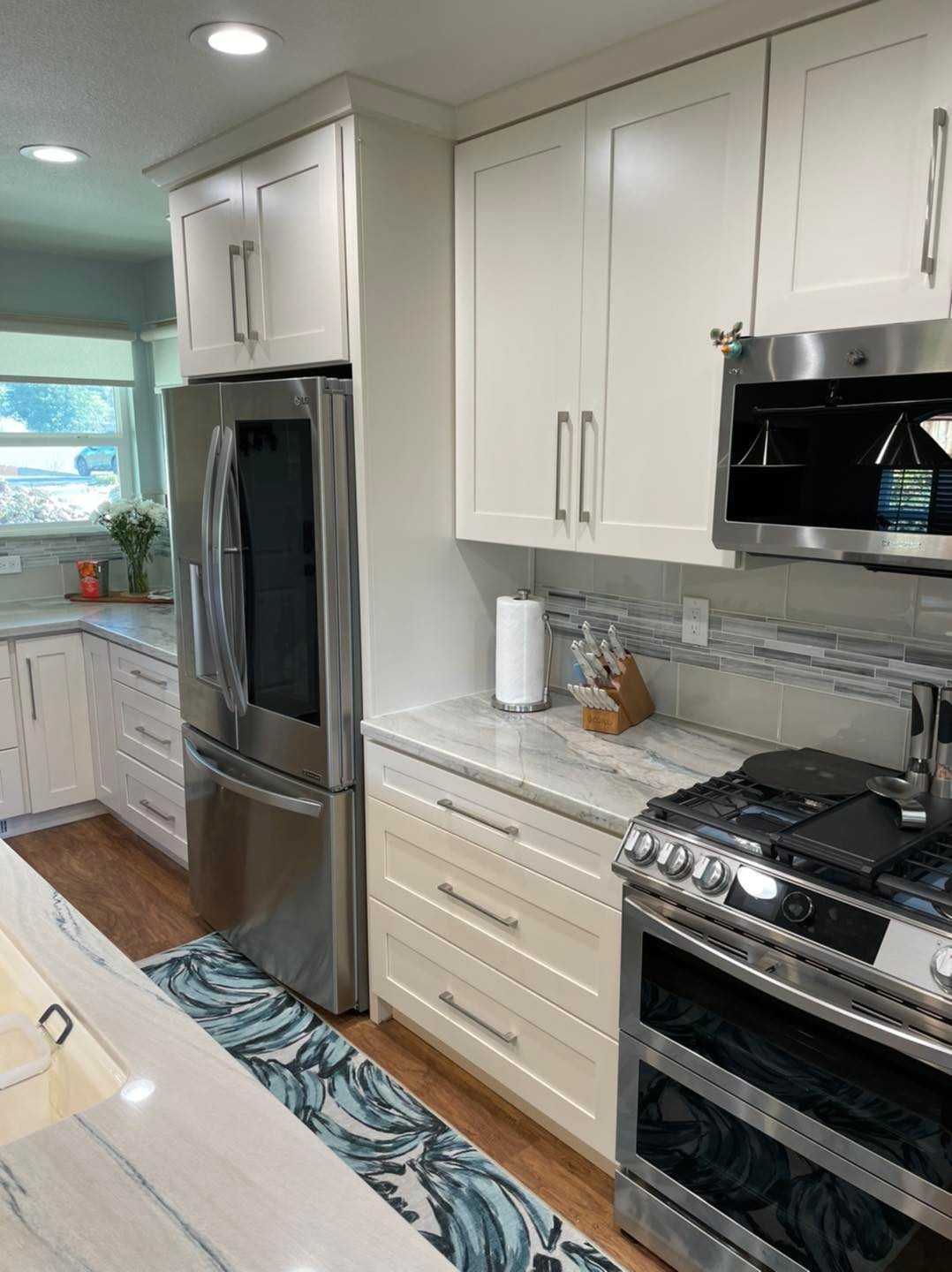 A kitchen with stainless steel appliances and white cabinets