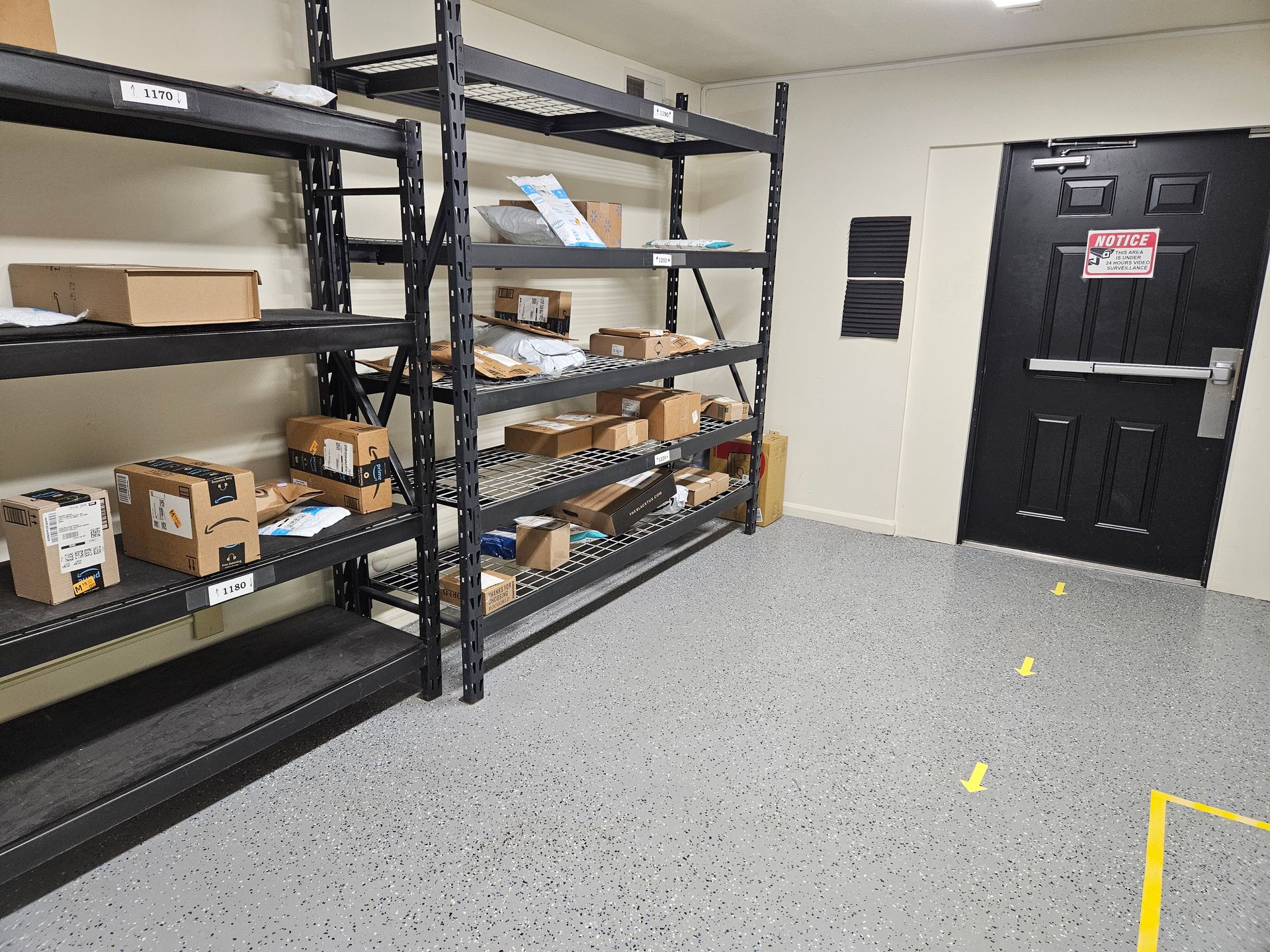 A room with shelves filled with boxes and a door.
