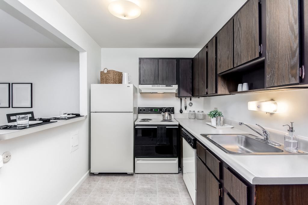 A kitchen with a refrigerator , stove , sink and dishwasher.