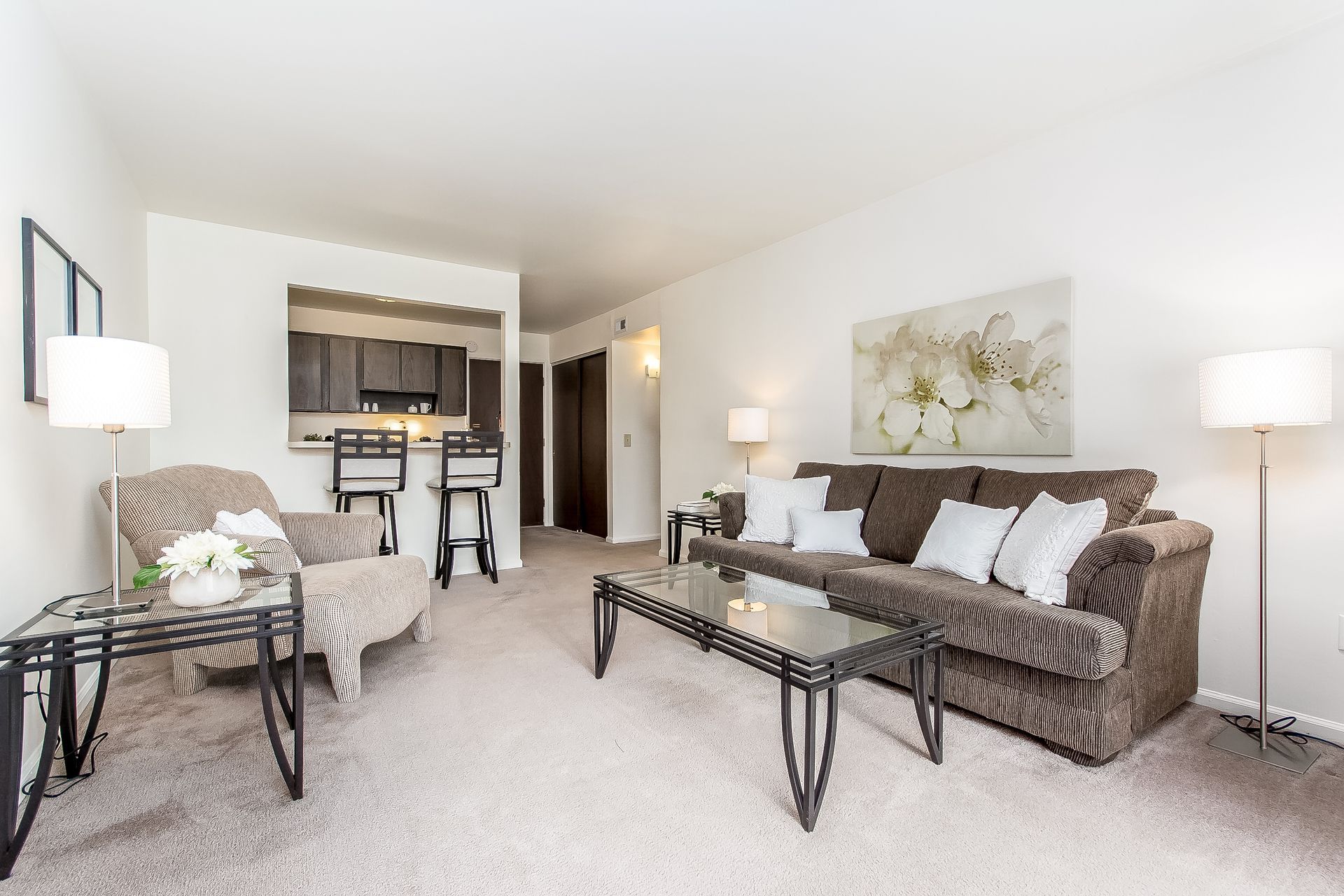 A living room with a couch , chair , coffee table and lamp