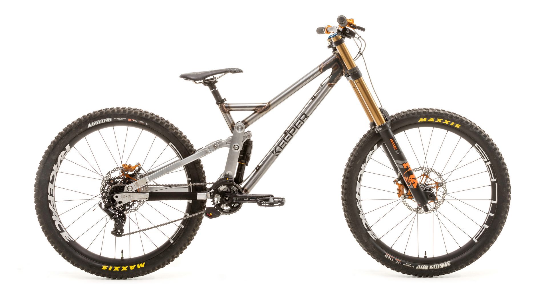 Silver mountain bike with orange suspension fork and wheels.
