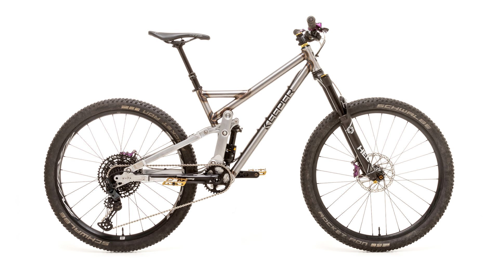 Mountain bike with silver frame, black tires, and purple accents.