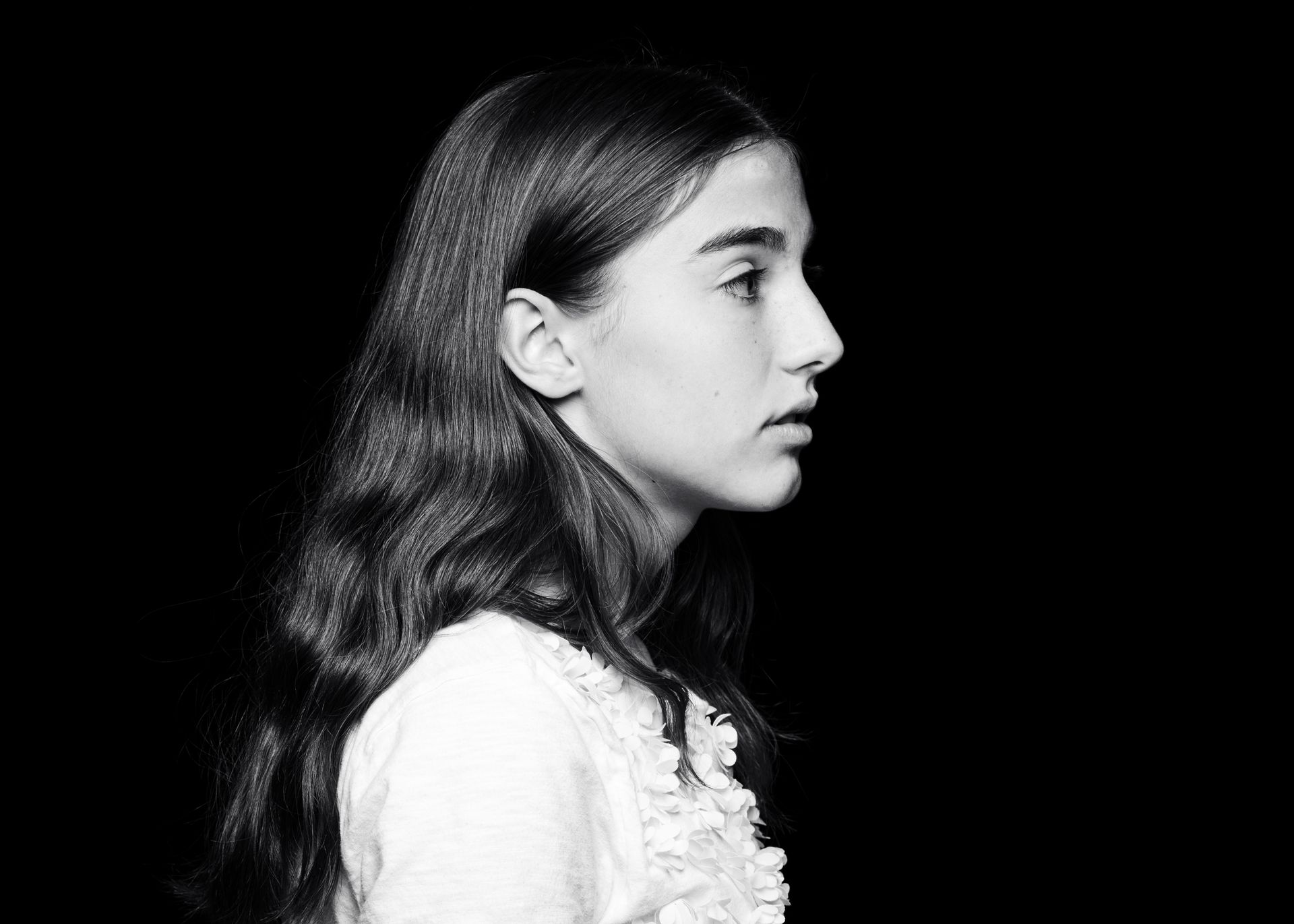 Fruit tart on a white plate: strawberries, blueberries, and yellow glaze on a pastry crust, blue background.
