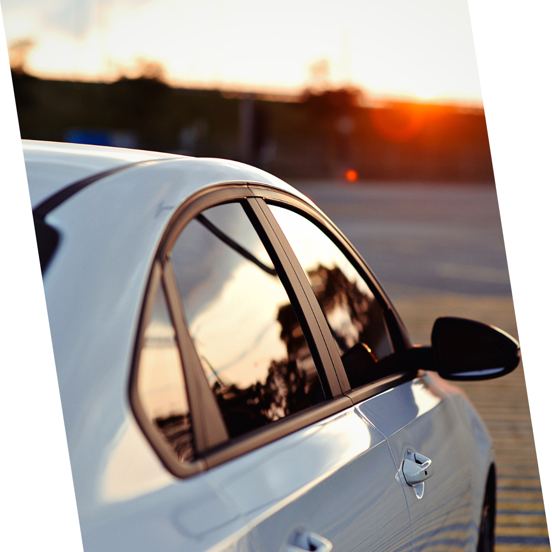 a white car is parked in a parking lot at sunset