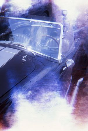 Classic black roadster, with racing stripes, against a blue and white ethereal background.