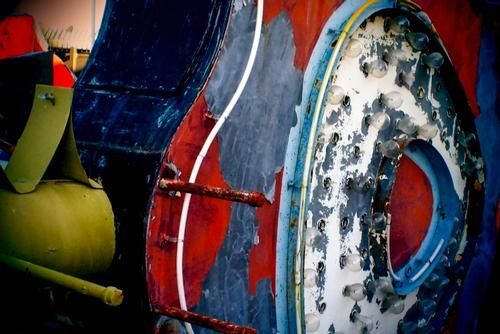 Close-up of weathered, colorful, and rusted industrial equipment.